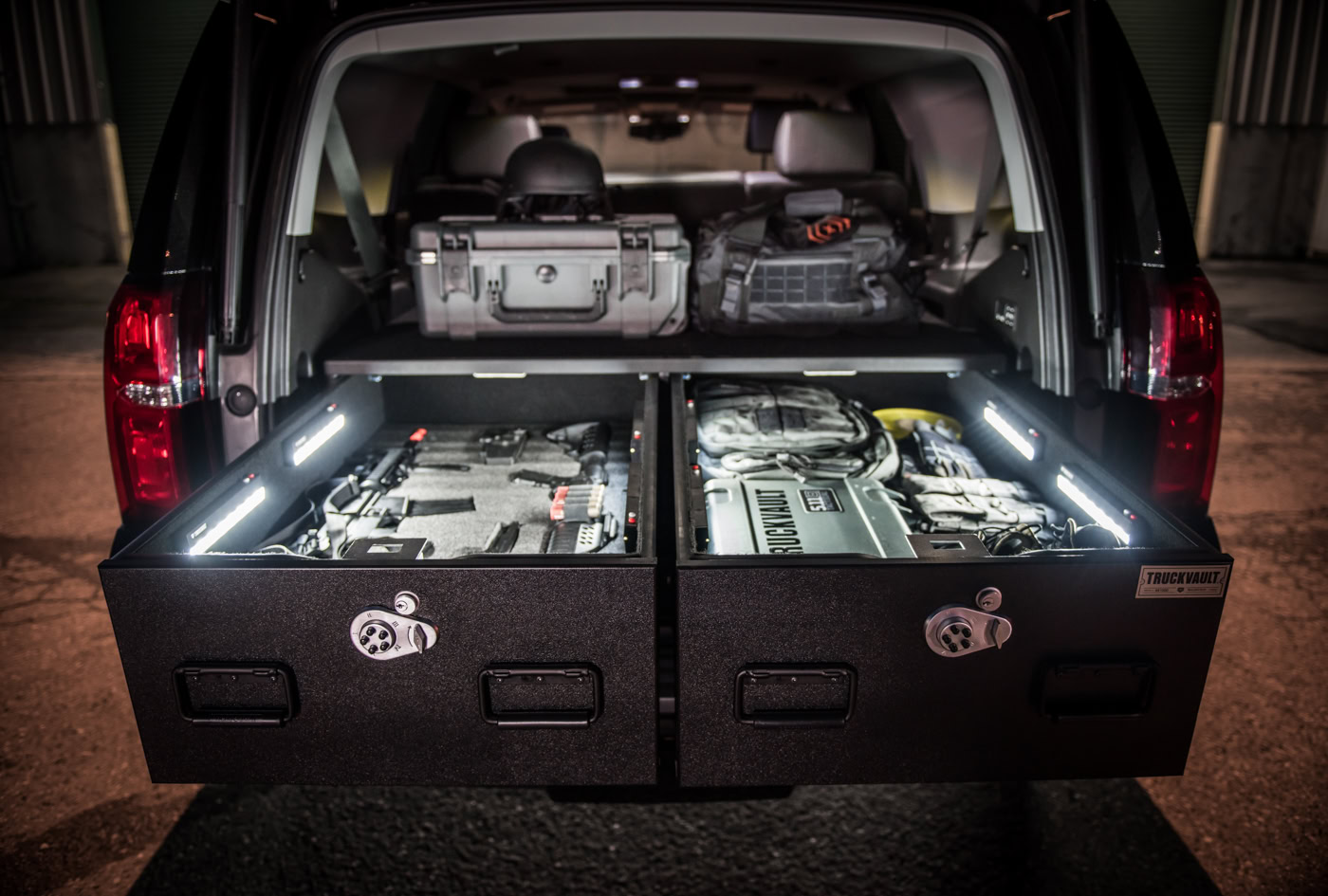 Chevrolet Tahoe with TruckVault drawers open showing gear illuminated by TruckVault LED lights